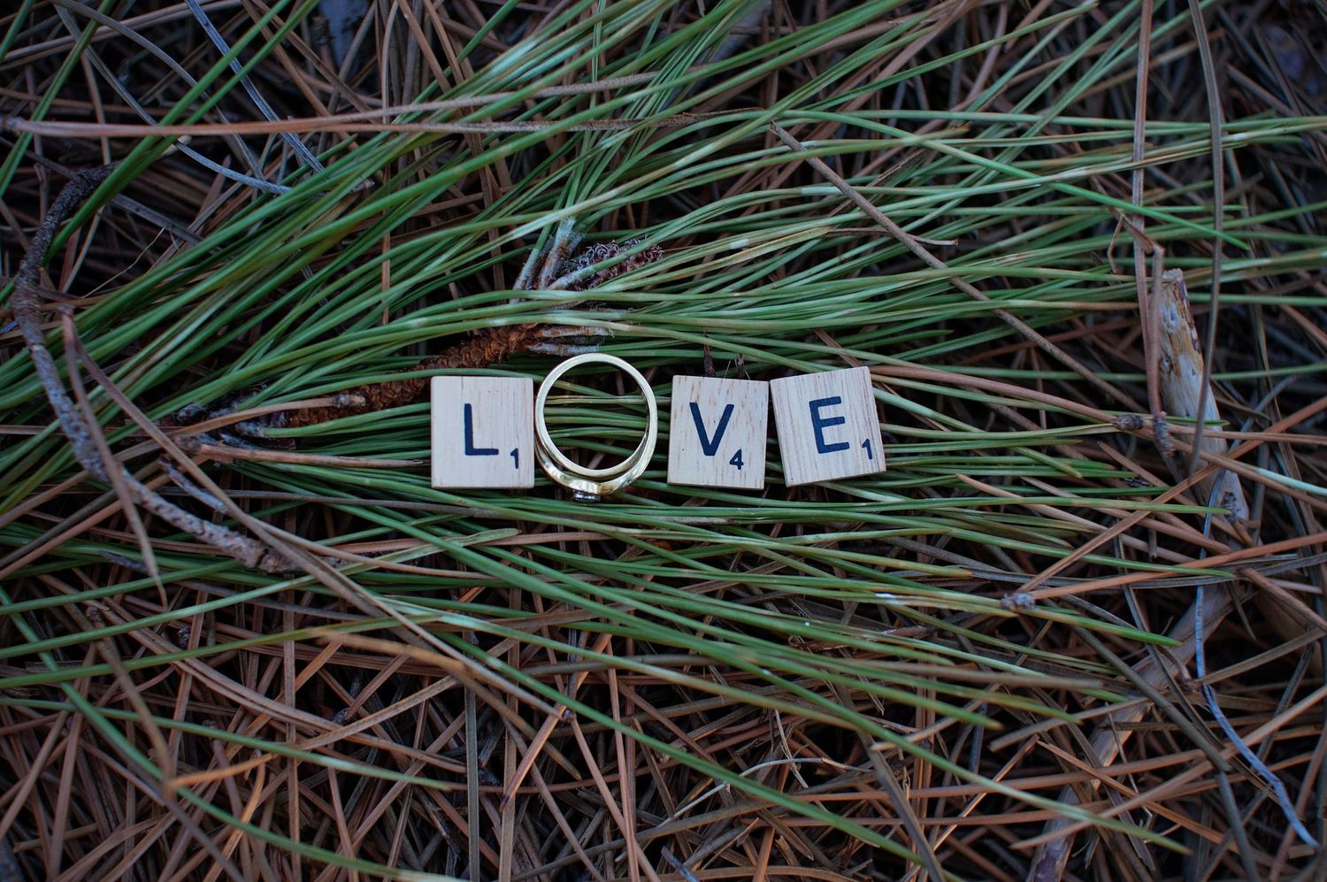 letters spelling out love with engagement ring