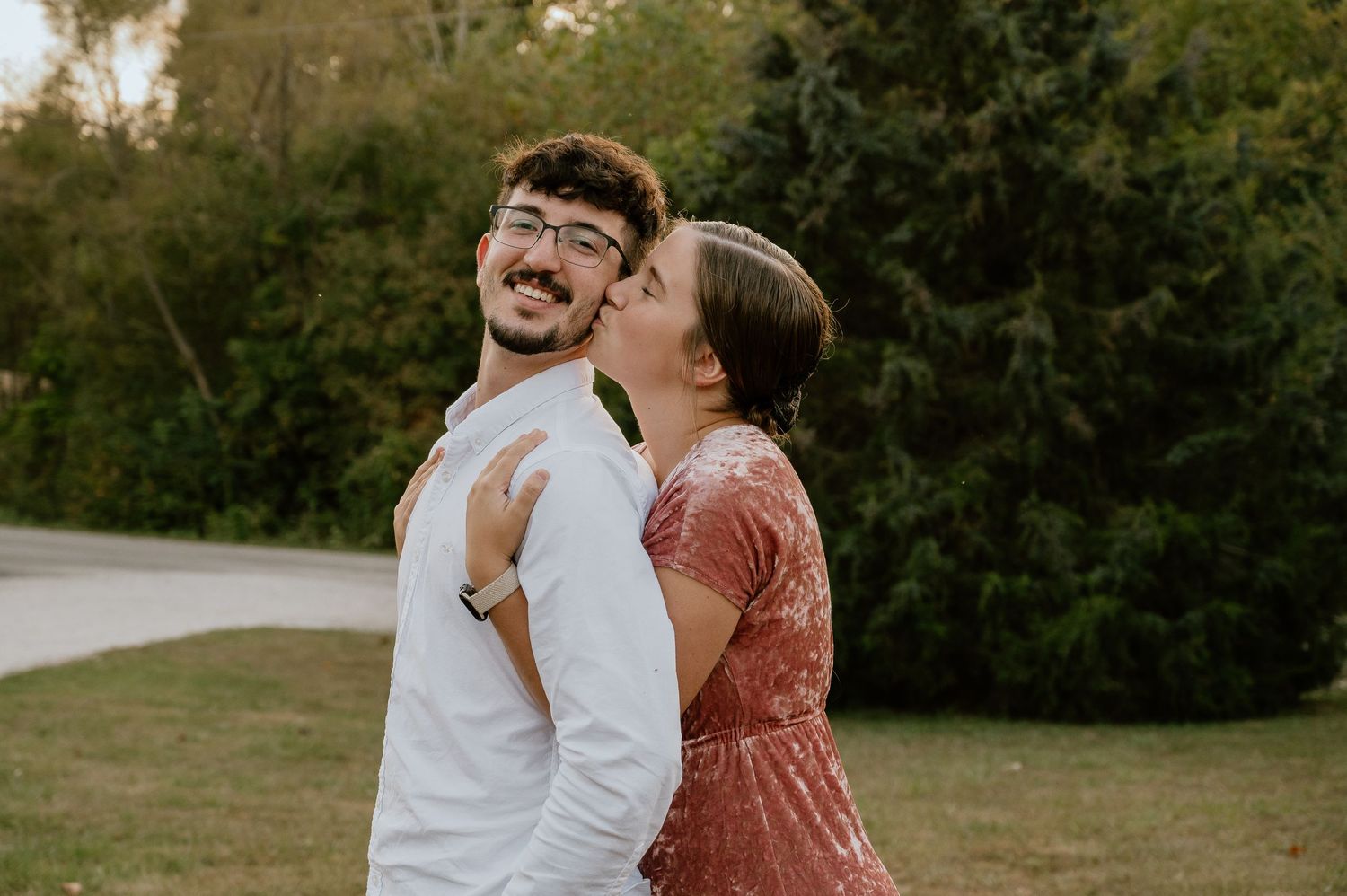 A couple shares a playful moment while laughing together in an outdoor setting.