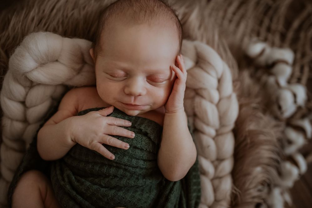 Newborn lifestyle session in Lincolnton NC with baby swaddled in neutrals