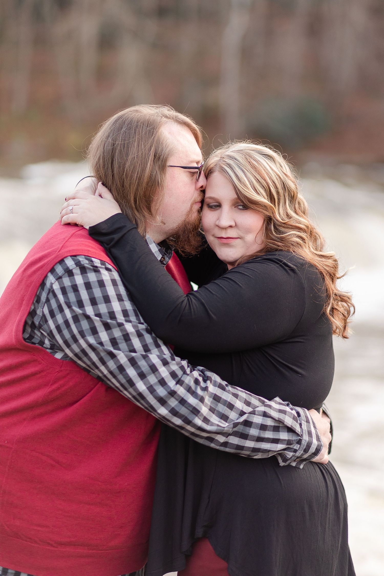A tender romantic moment shared between a couple wearing coordinating red and black outfits.