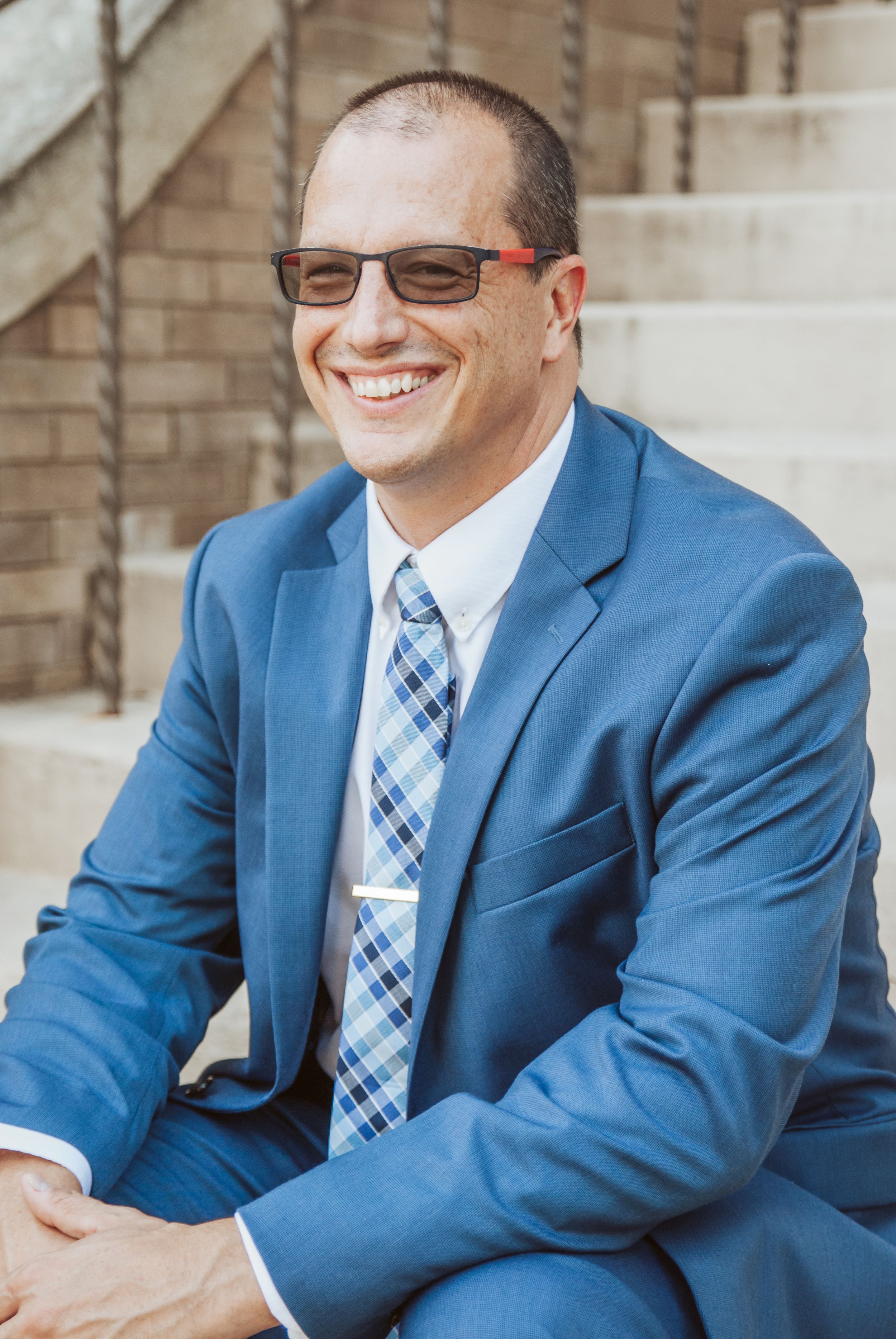 a portrait headshot of a male sitting on stairs
