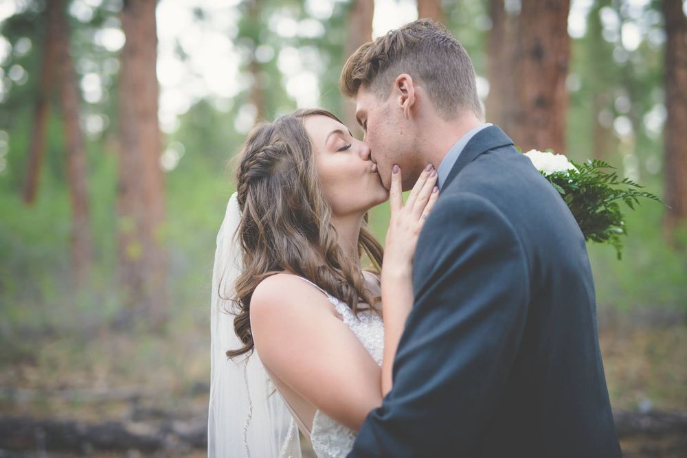 bride and groom kissing in the forest