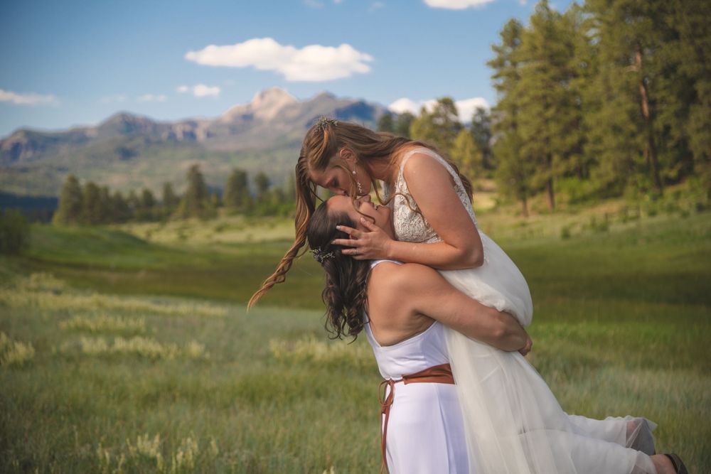 a same sex female couple embracing at their wedding in front of Pagosa Peak in Colorado