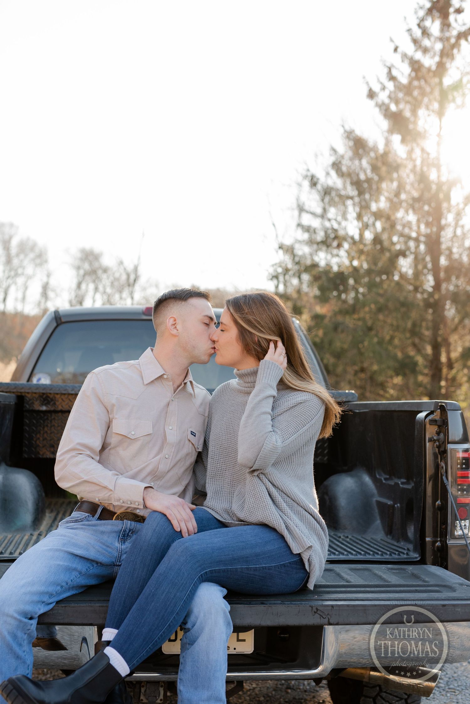 Romantic couple sharing an intimate moment while sitting in the bed of a pickup truck.