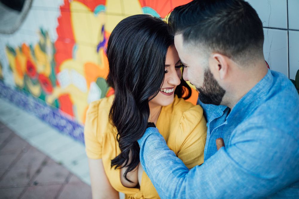 couple smiling at each other during an engagement session in Calle Ocho Miami Florida