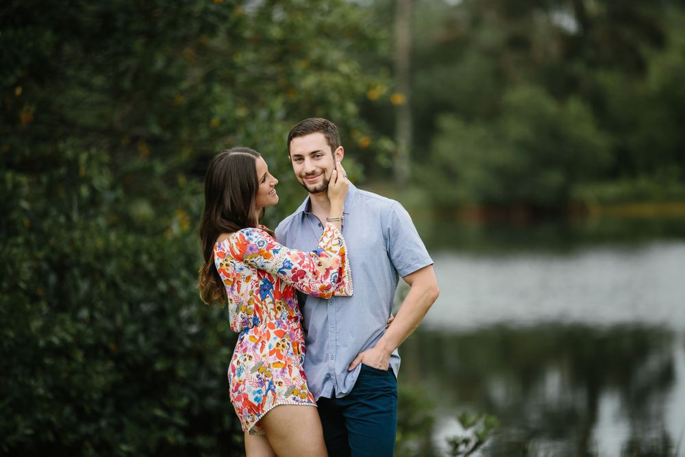 woman embracing man while man looks at the camera during engagement session in Matheson Hammock park in Miami Florida
