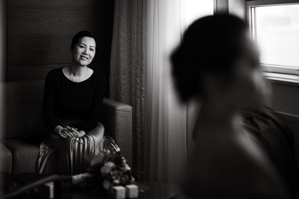 Artistic black and white portrait in window light with reflective composition.