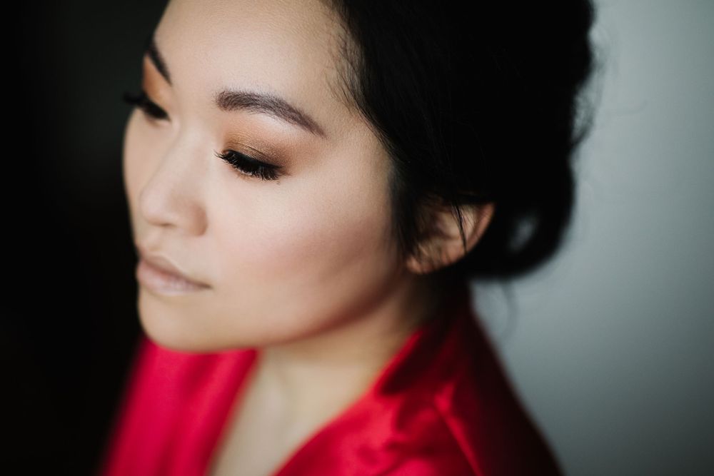 Close-up portrait of someone in a vibrant red outfit against a dark background.