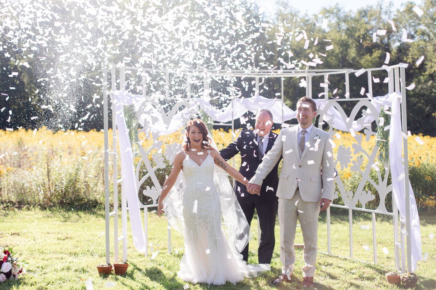 A wedding celebration with confetti flying through the air during an outdoor ceremony.