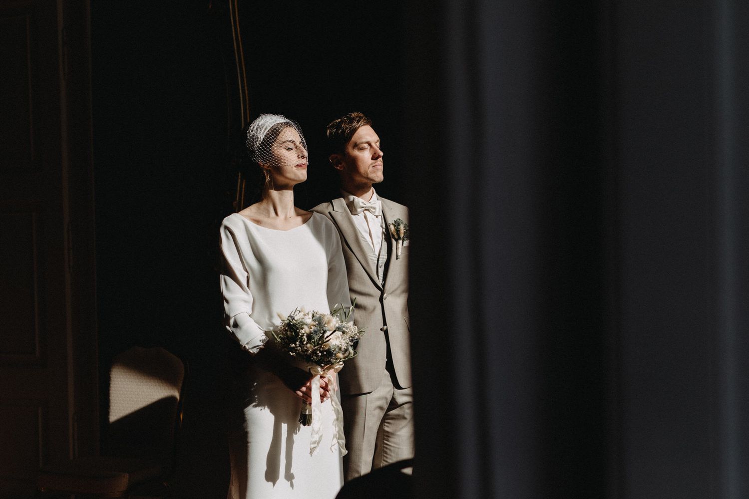 A dramatic wedding portrait capturing an intimate moment in moody lighting.