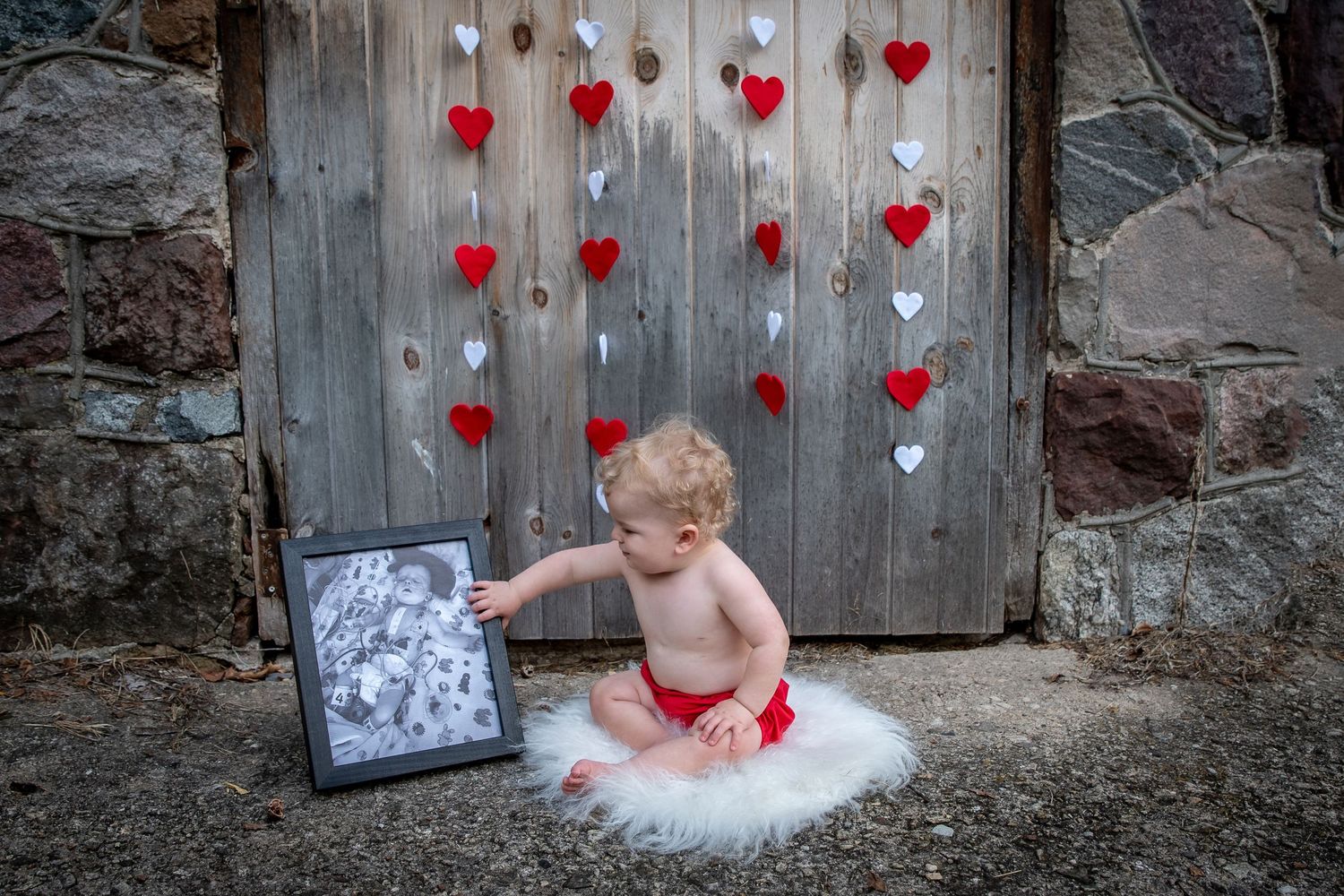 Valentine's day themed decorations with red and white hearts on a rustic wooden door.