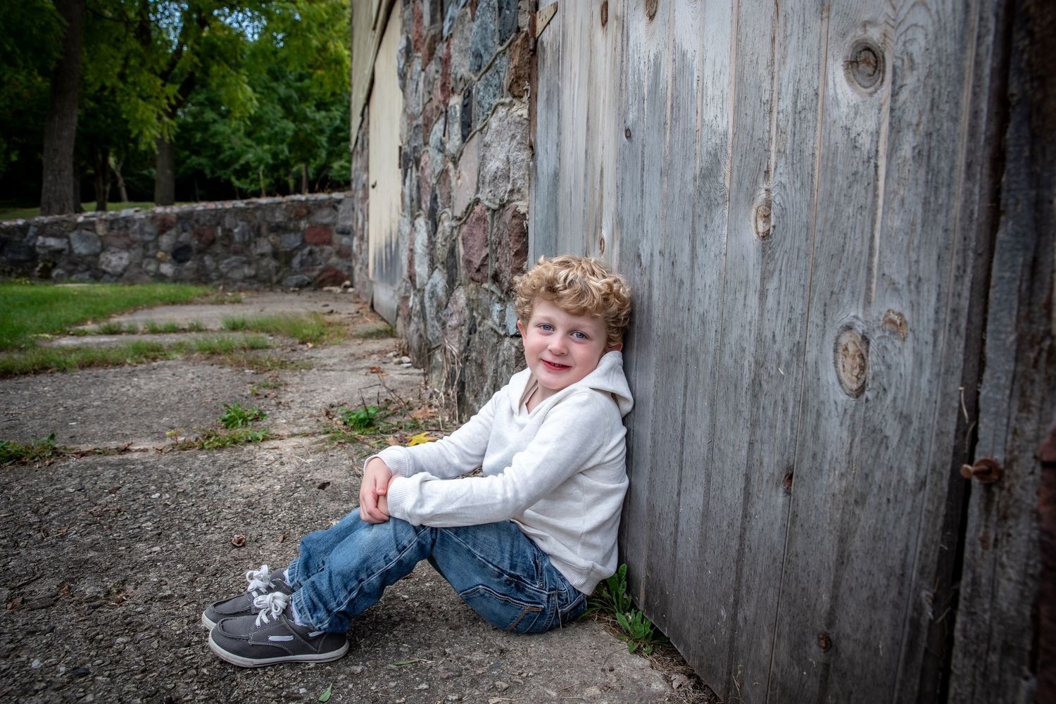 A rustic weathered barn wall creates a textured backdrop in an outdoor setting.