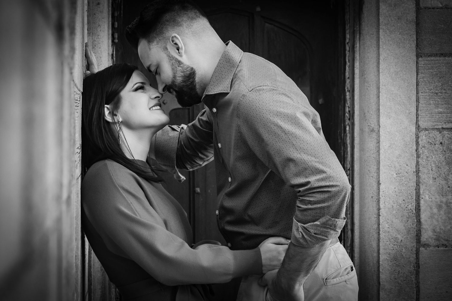 A couple steals a kiss in a timeless black and white picture