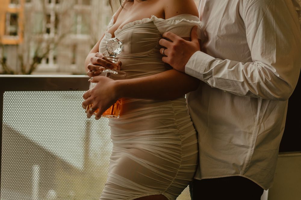 Person wearing an off-shoulder cream dress in soft lighting.