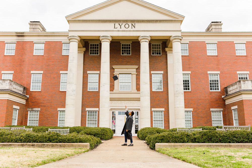 Stately red brick academic building with white columns and 'LYON' text above entrance.