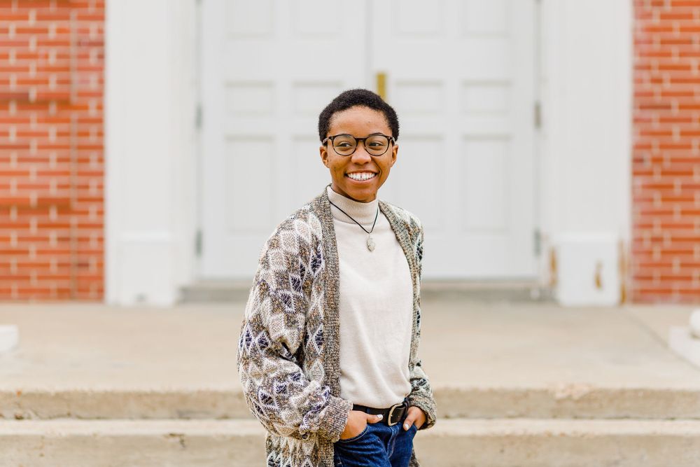 Stylish outfit featuring a patterned cardigan and jeans on campus grounds.