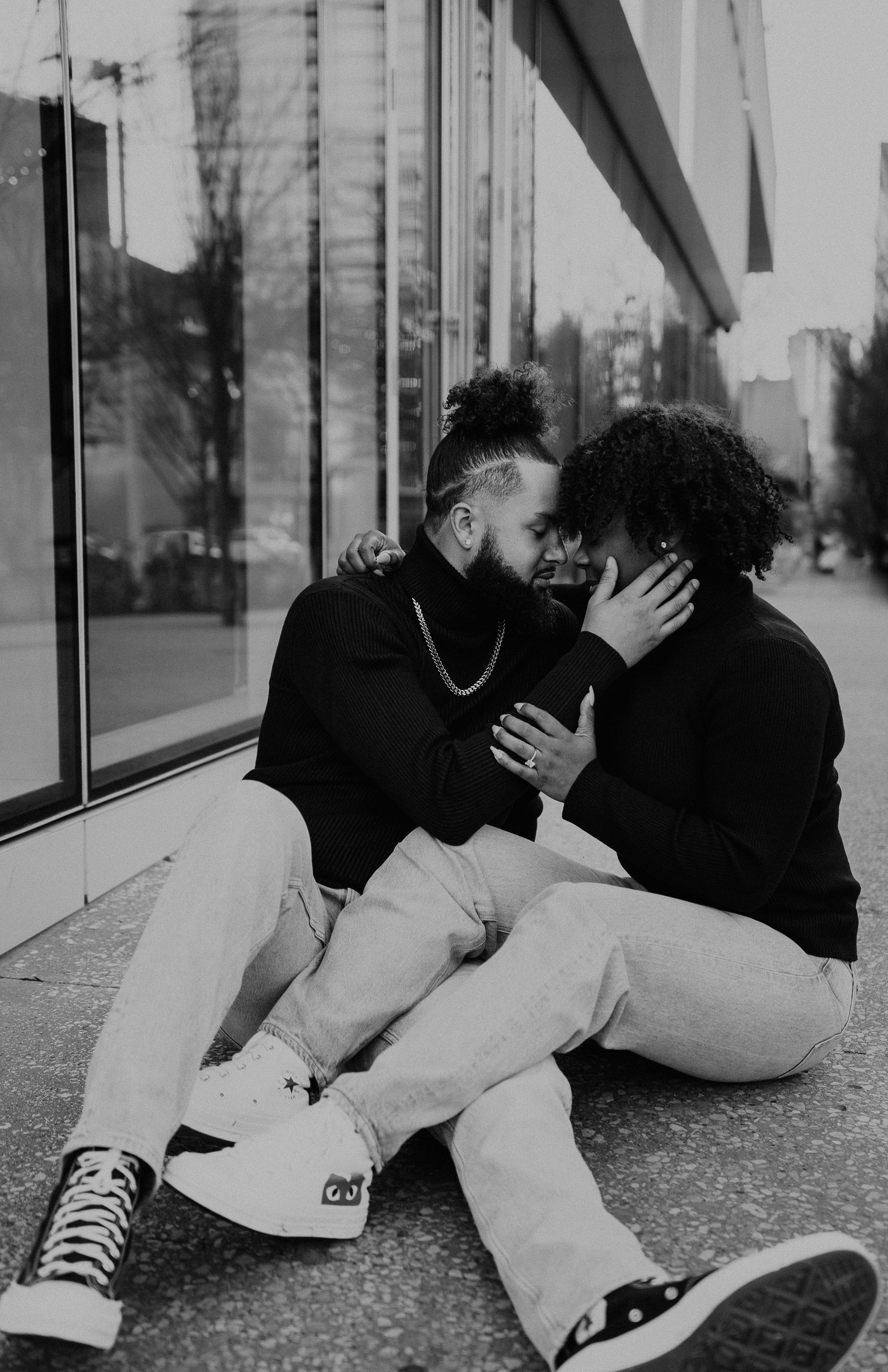 couple sitting down for engagement photos in downtown dallas. alex marie photography.