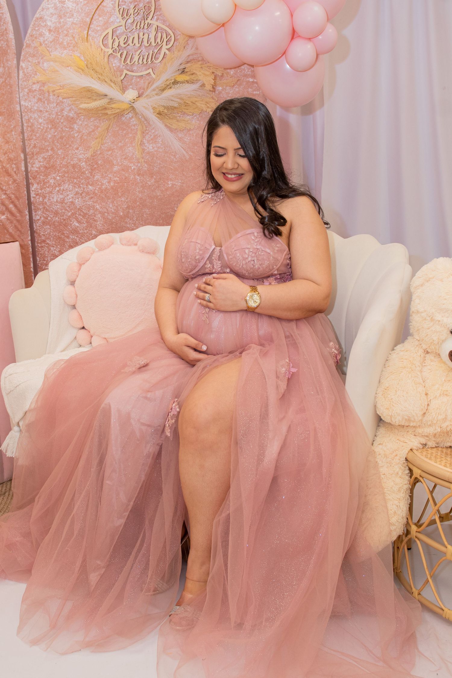 Maternity photo featuring pink tulle dress in soft romantic setting with balloon decorations.