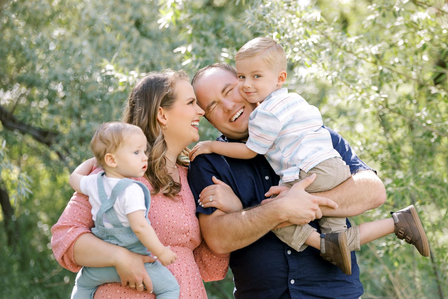 Happy family shares loving embrace outdoors in spring garden setting.