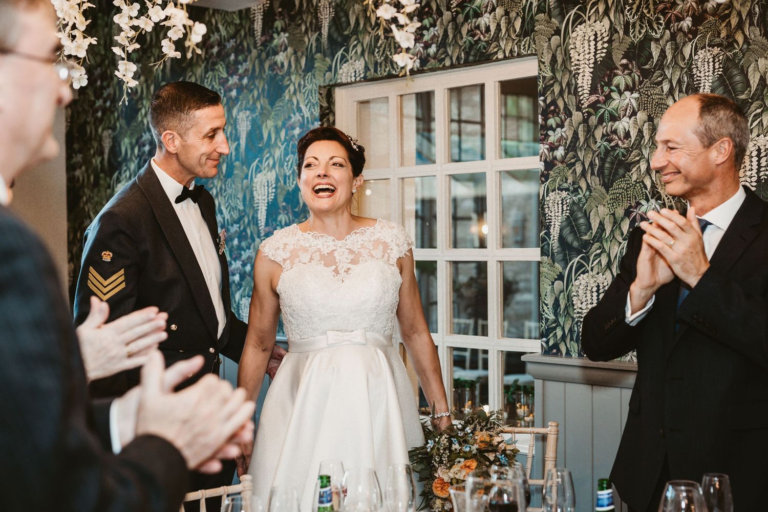 Wedding celebration scene with couple and guests clapping indoors.