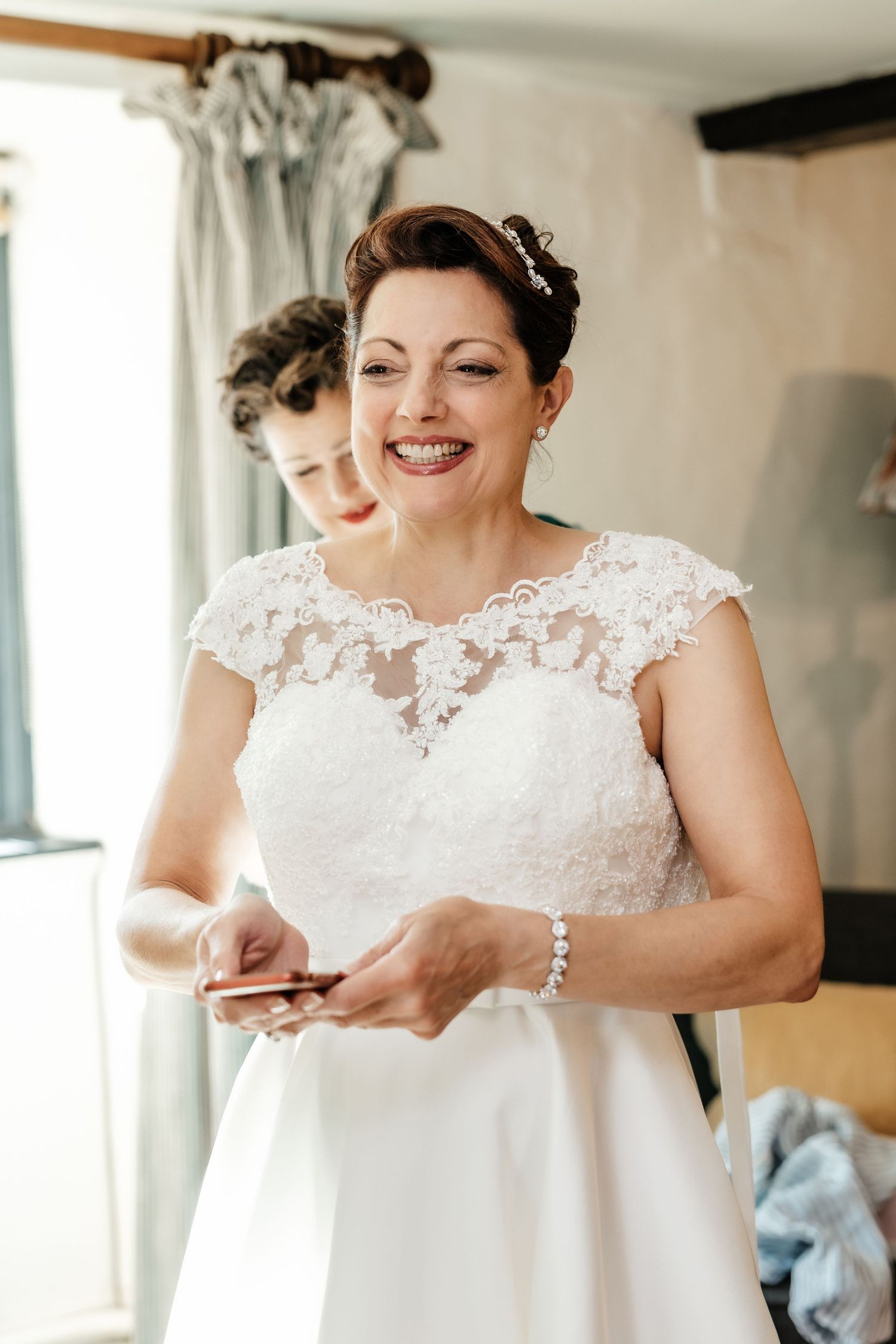 Wedding preparation scene featuring white lace dress detail in sunlit room.