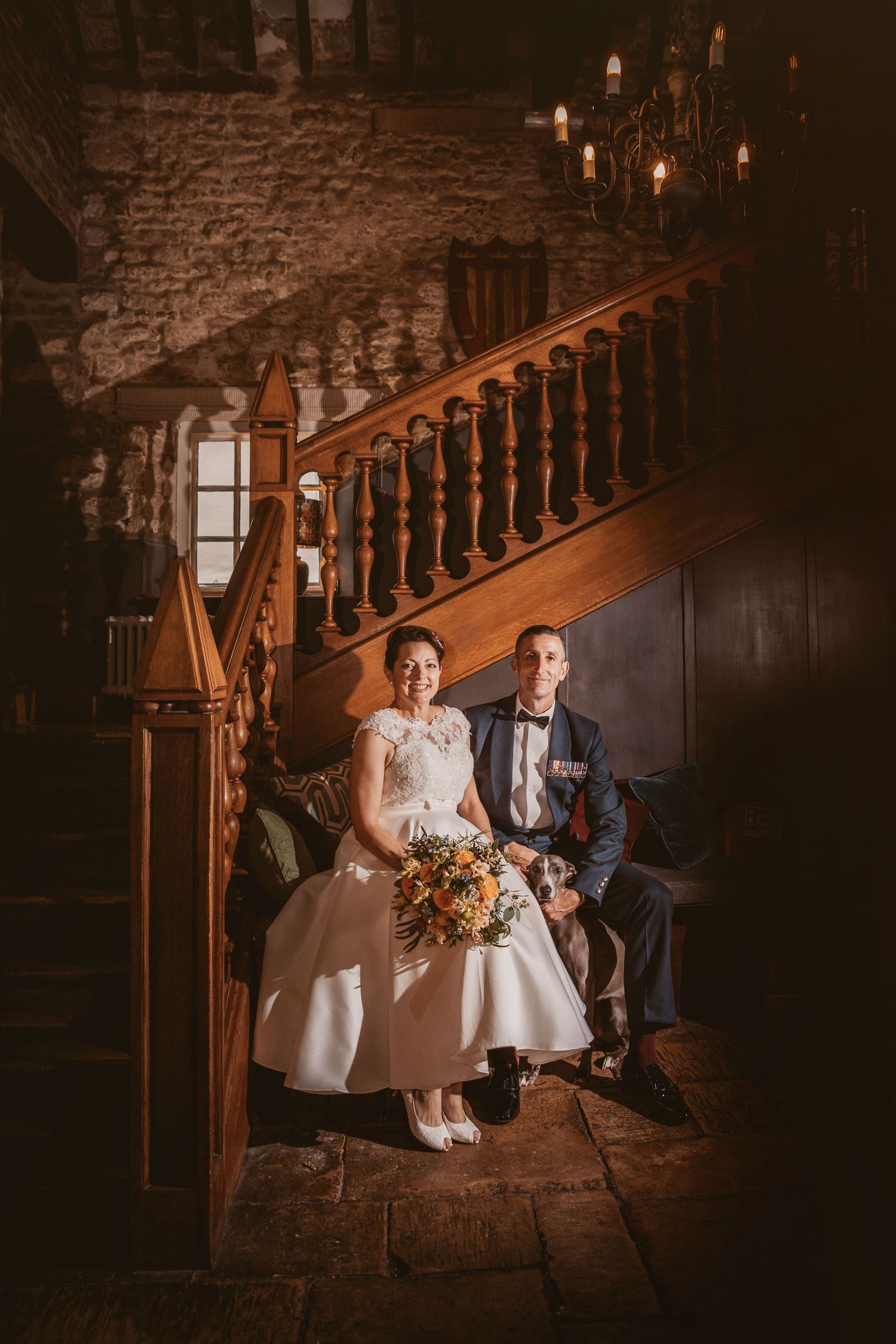 Romantic wedding portrait on historic stone staircase with candlelit ambiance.