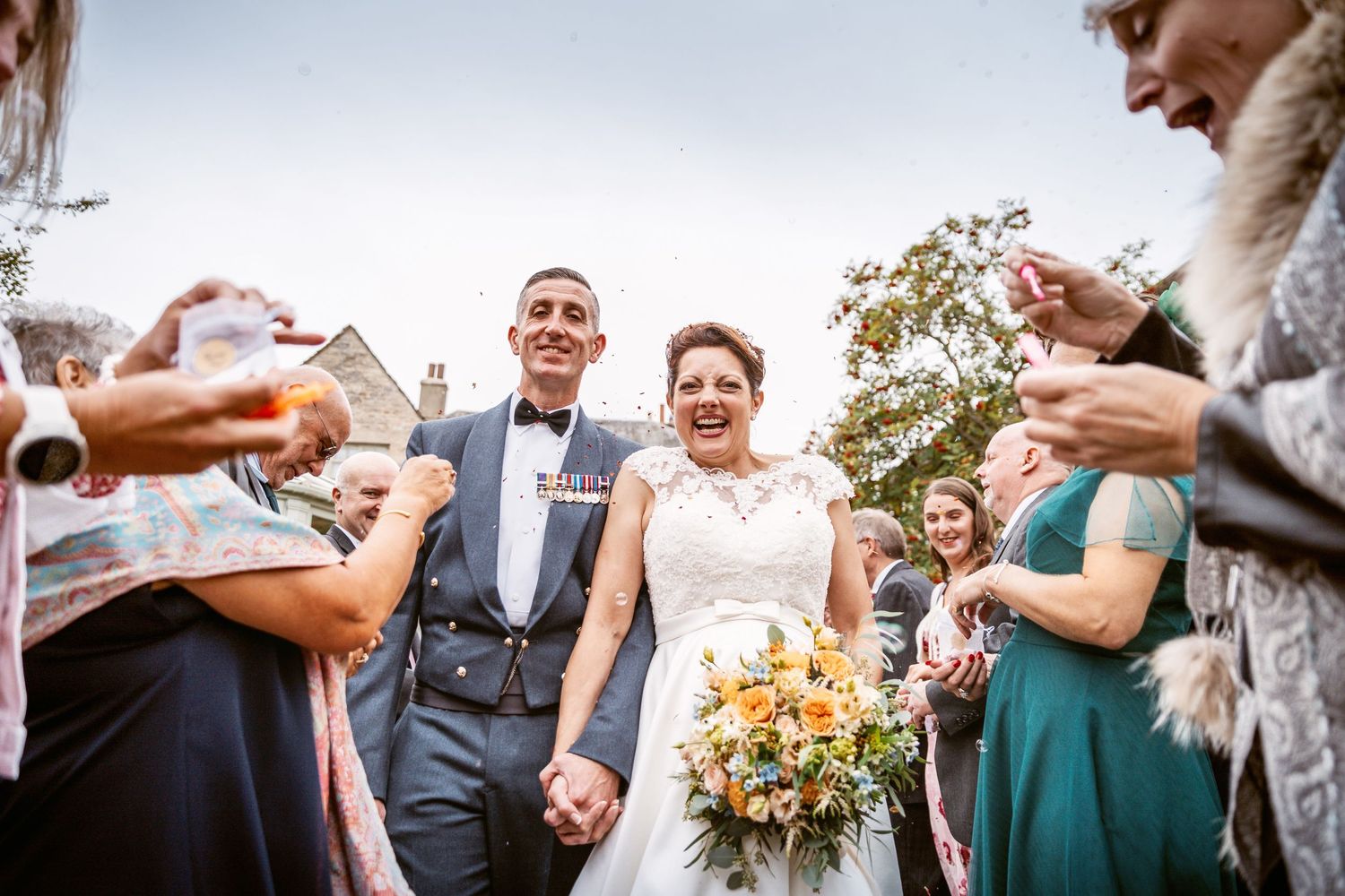 Wedding guests raise glasses to toast the happy couple during outdoor celebrations.