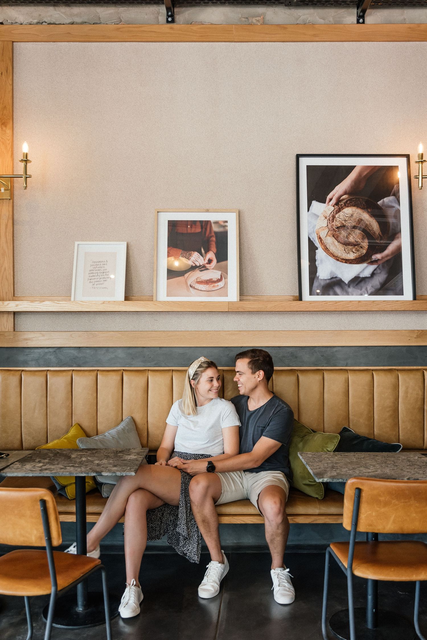 Couple intimately sitting on a couch in a cafe, sharing a warm gaze, creating an atmosphere of romance and familiarity