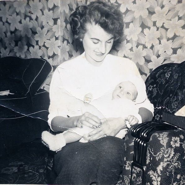Vintage black and white photograph showing a tender moment on a patterned couch.