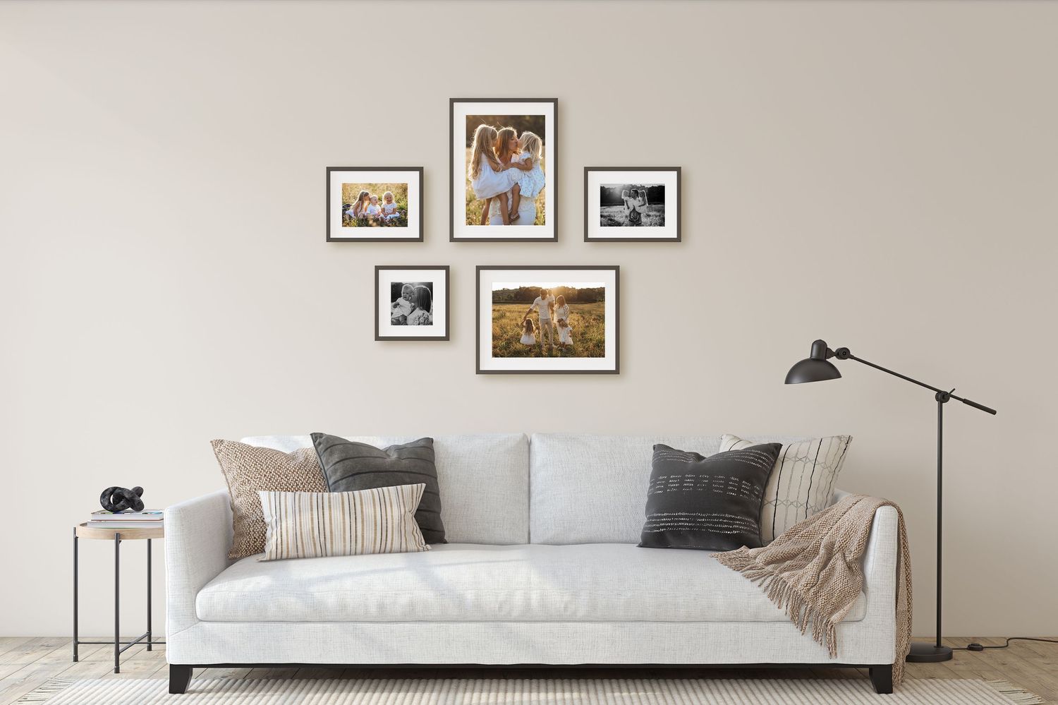 Gallery wall of five framed family portrait photos arranged above a white sofa in a living room.