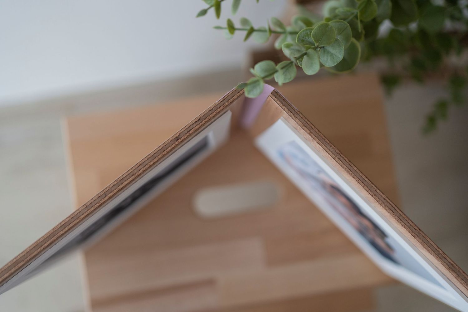 Close-up of elegant photo album with rose gold spine resting on wooden surface.