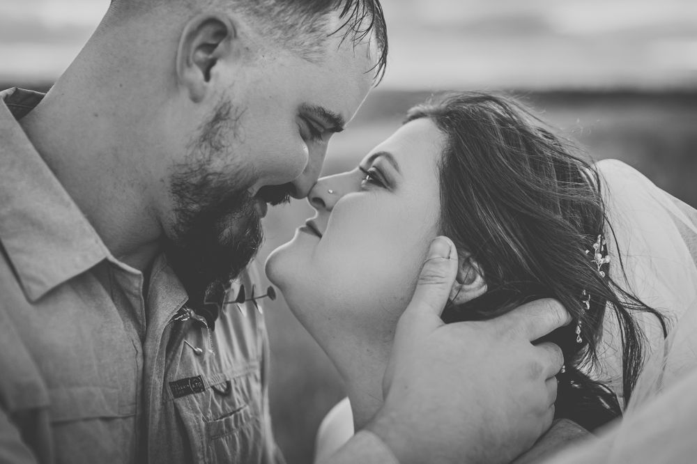 Intimate black and white close-up photo of a romantic kiss between a couple.