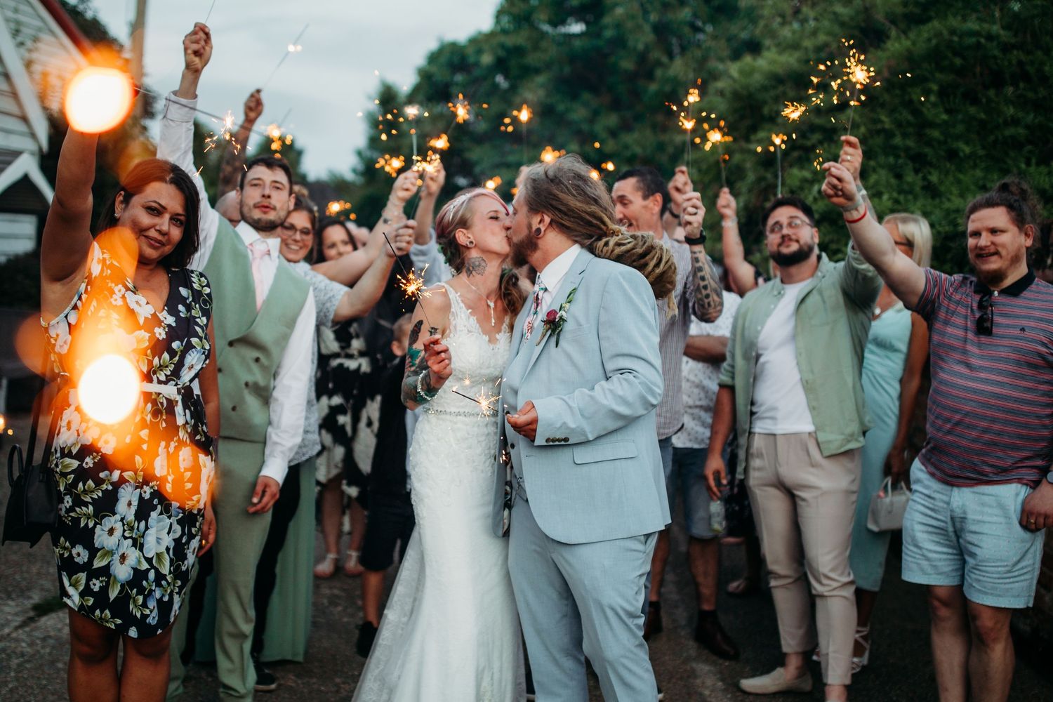 Wedding celebration at dusk with sparklers creating a magical atmosphere.