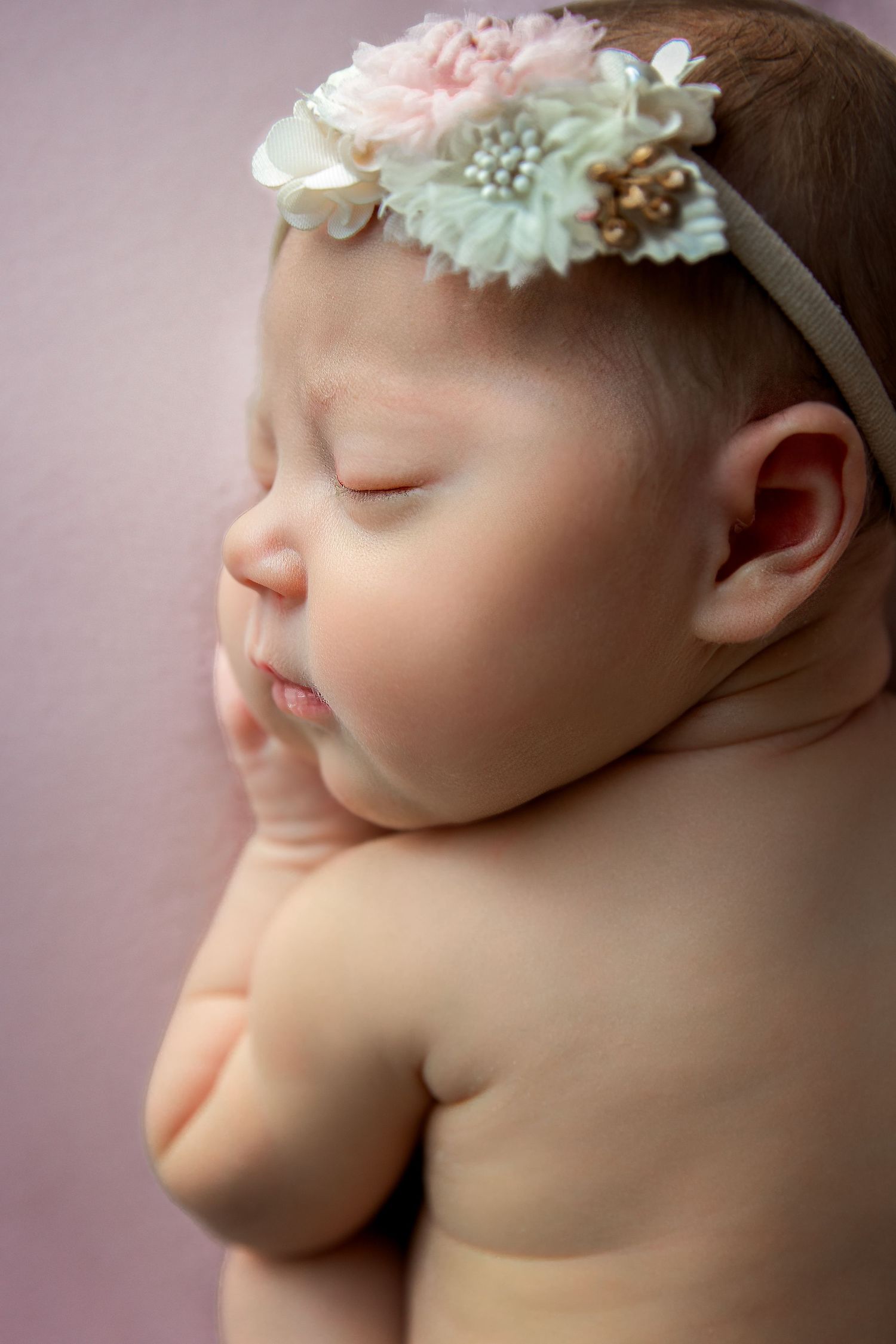 close-up side profile of newborn baby with hair band for newborn photography