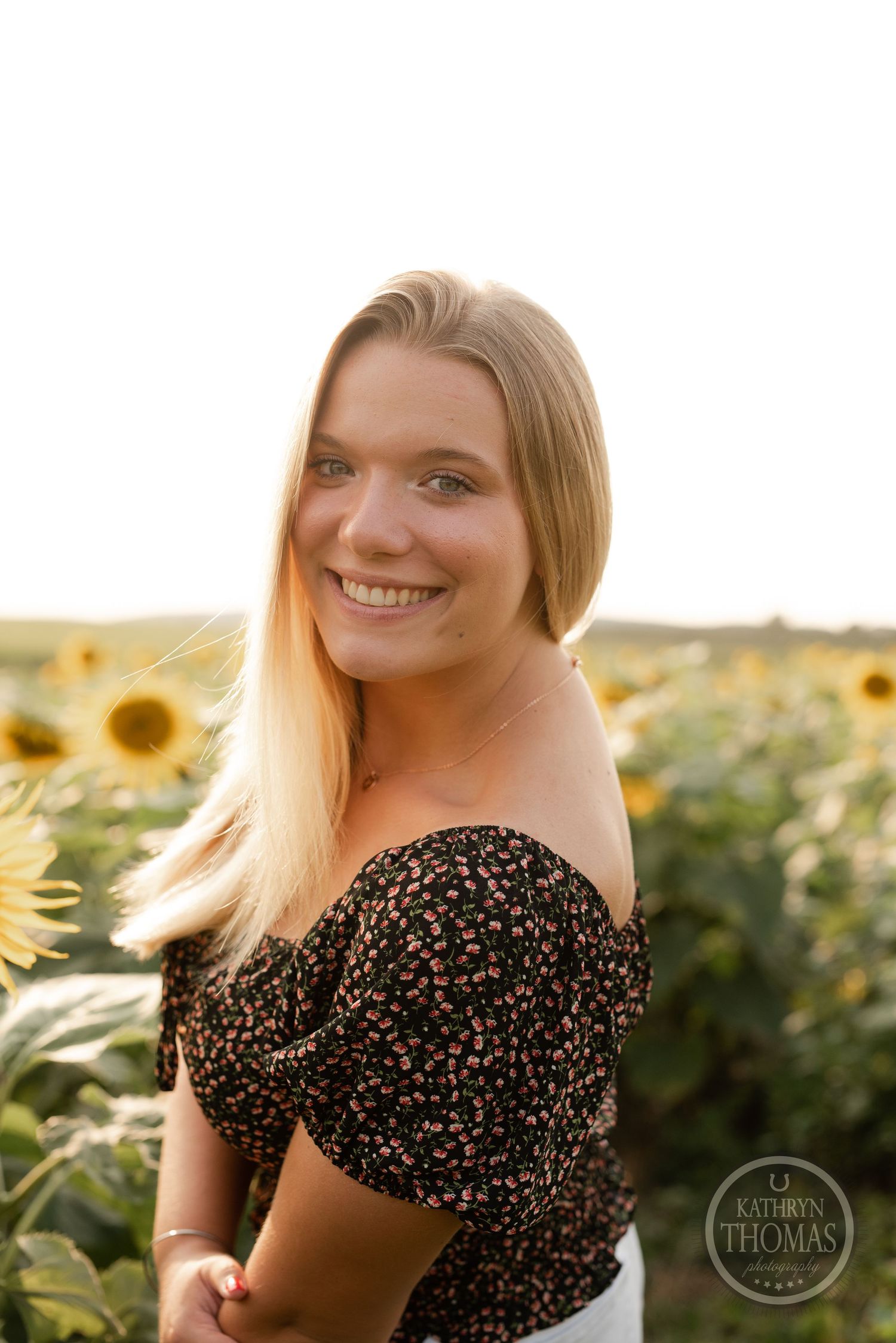 A close-up portrait in golden light with sunflowers creating a natural backdrop.
