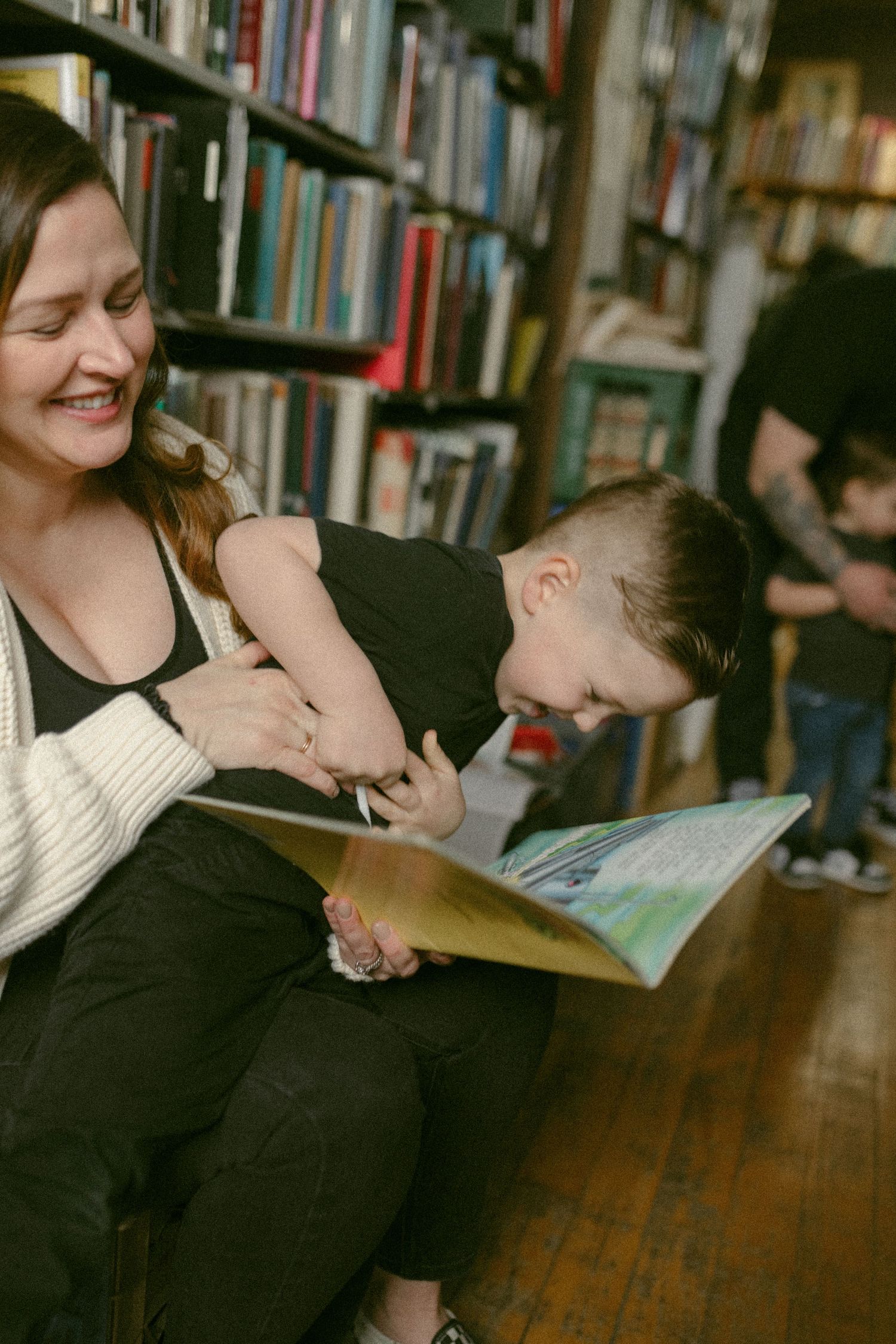 Joyful moment of reading and laughter in a library setting.