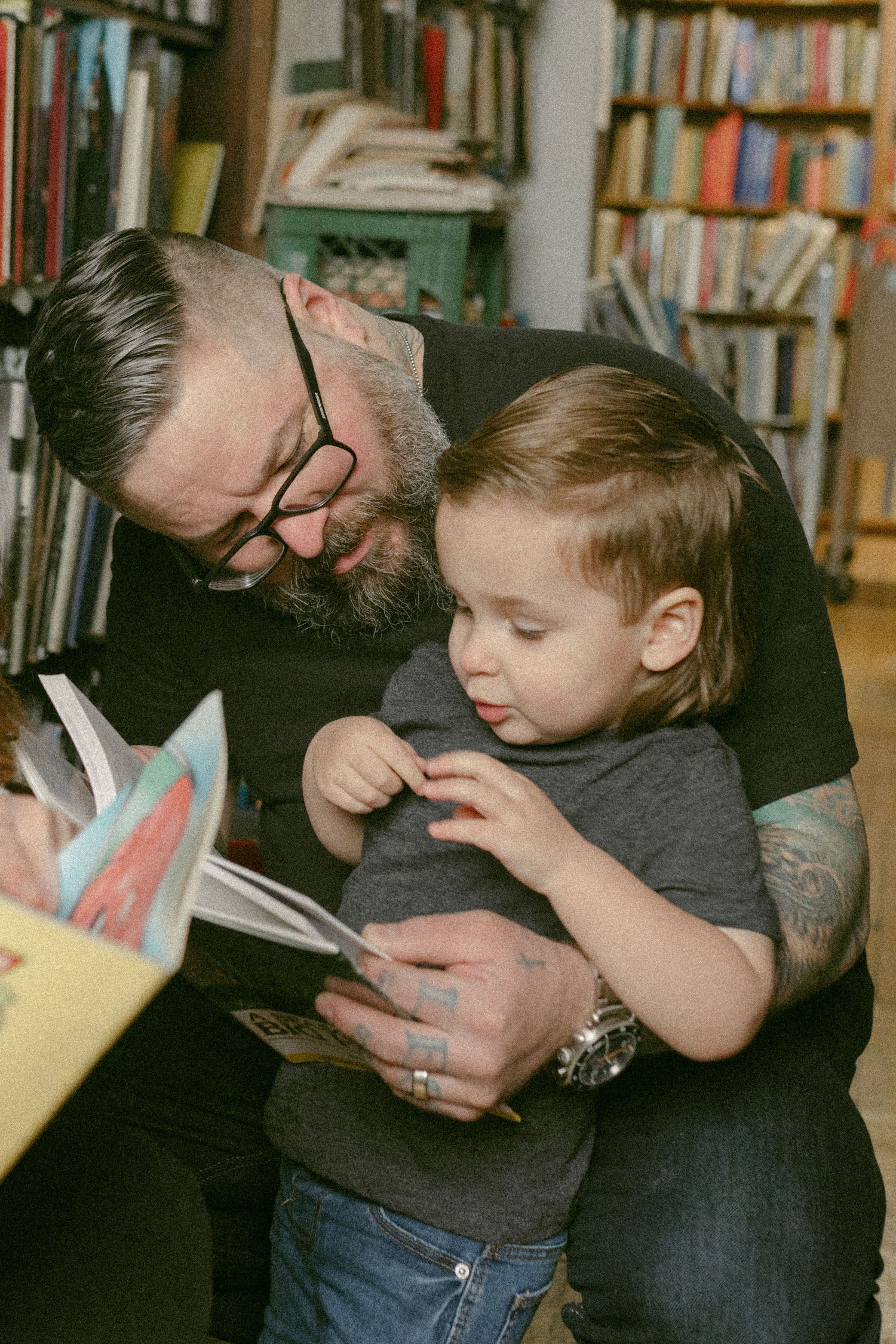 Sharing a special reading moment together among library bookshelves.