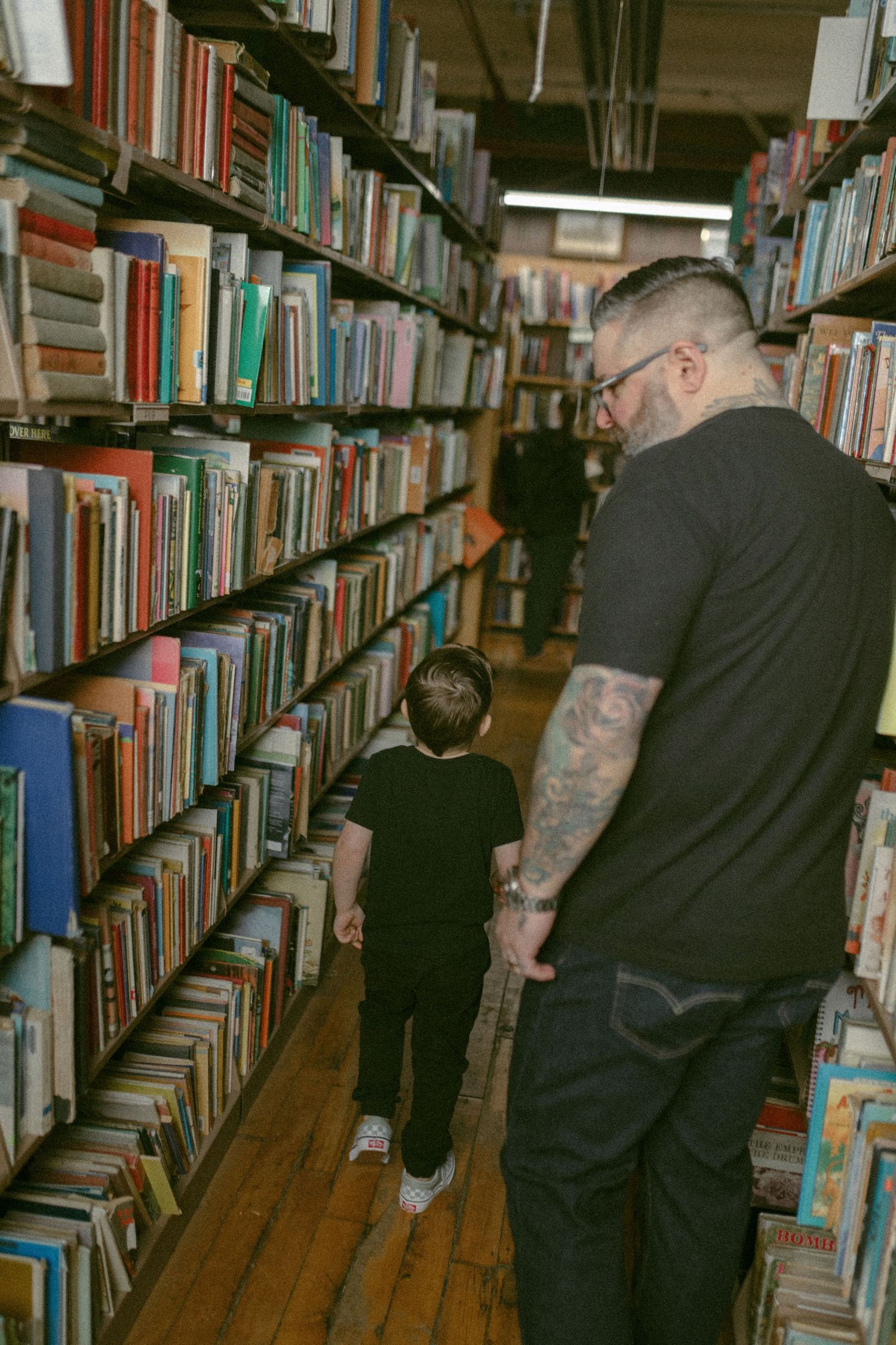Walking through library aisles between tall bookshelves filled with colorful books.