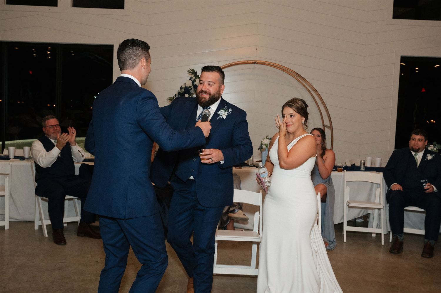 A wedding toast moment during the reception with guests in formal attire.
