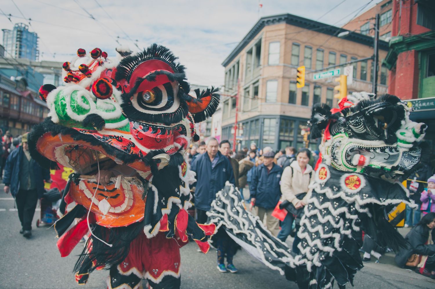 Colorful Chinese dragon dance performers celebrate in an urban street festival.