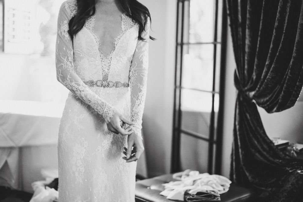 Close-up of lace wedding dress details with deep v-neckline.