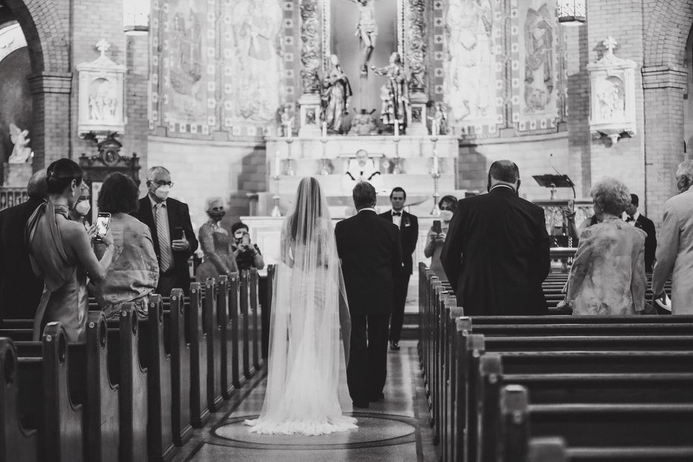 Classic black and white photo of a wedding ceremony in a grand church sanctuary.