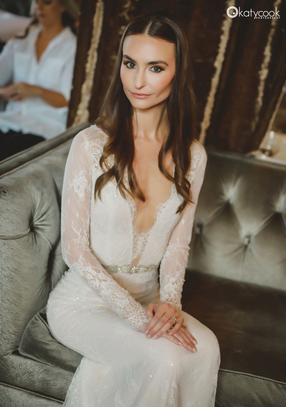 Elegant bridal portrait on vintage tufted sofa showing delicate lace details.