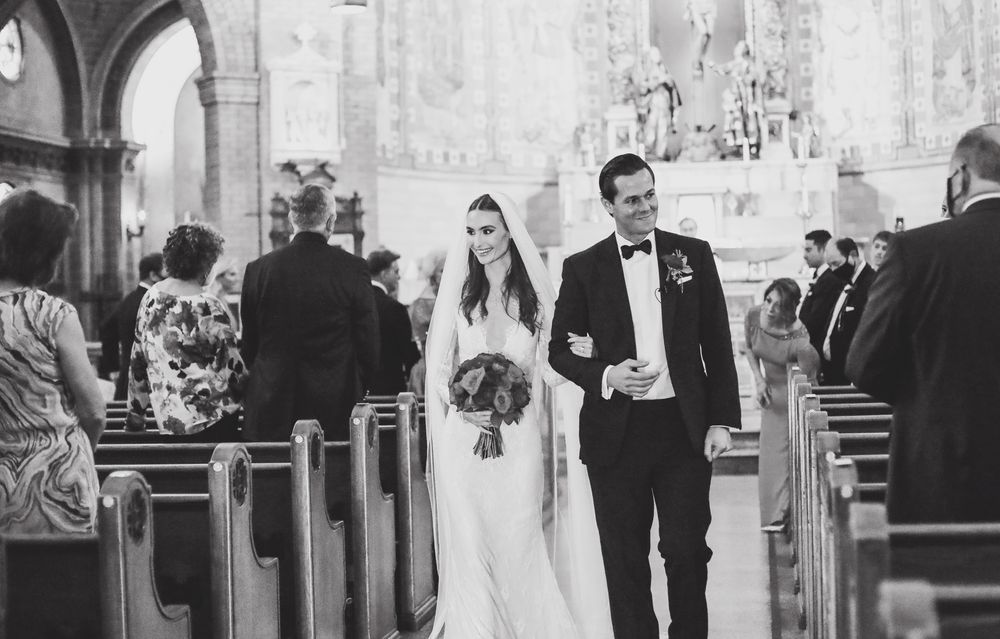 Church wedding ceremony processional in black and white with elegant formal attire.