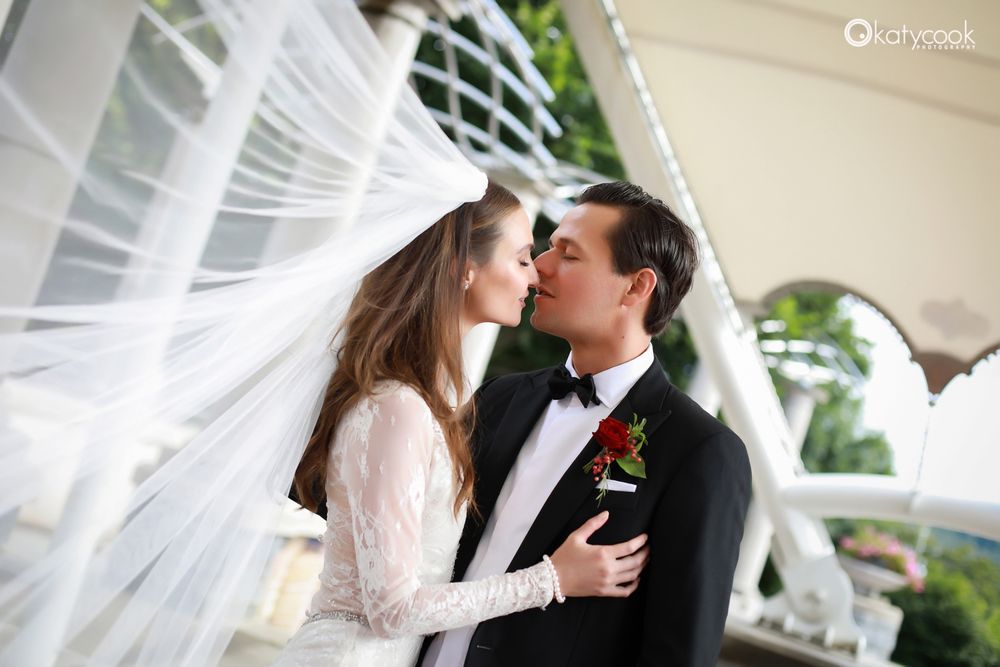 Romantic wedding portraits under white flowing fabric in an outdoor setting.