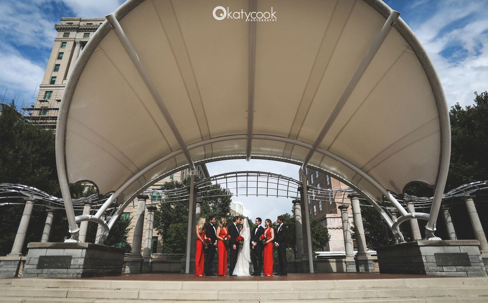 Wedding ceremony setup under large white canopy with blue sky backdrop.