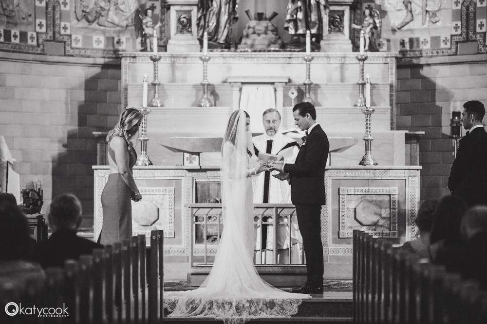 Church interior wedding ceremony with ornate altar and pews.