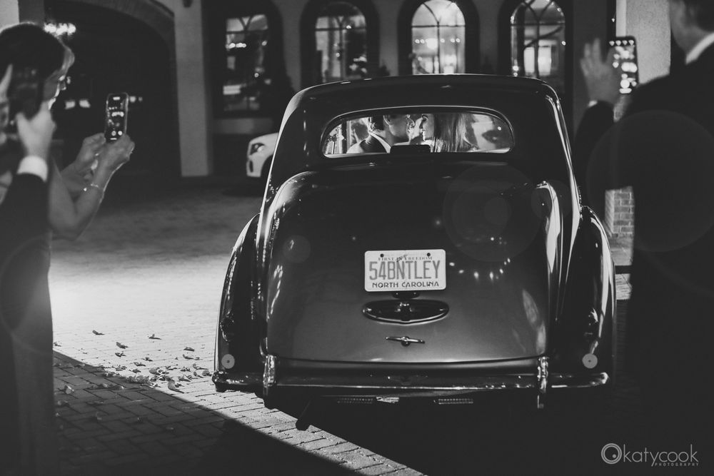 Vintage car illuminated at night showing retro license plate and chrome details.