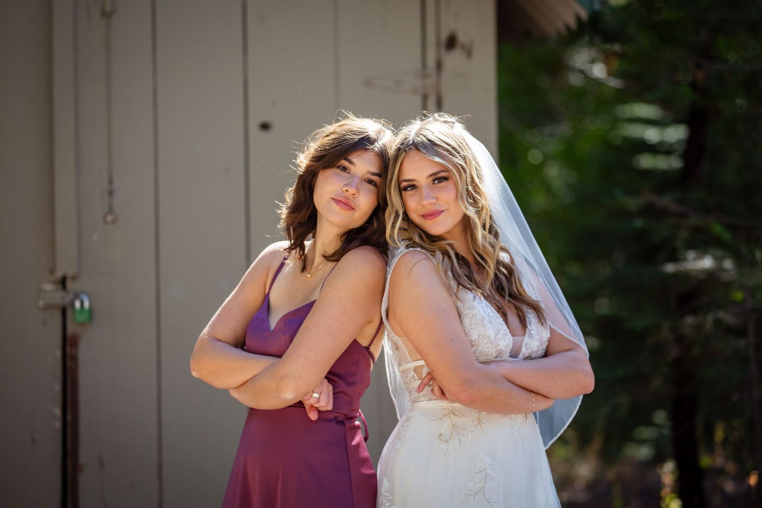 Two people in formal attire embrace and laugh together outdoors during a photo session.