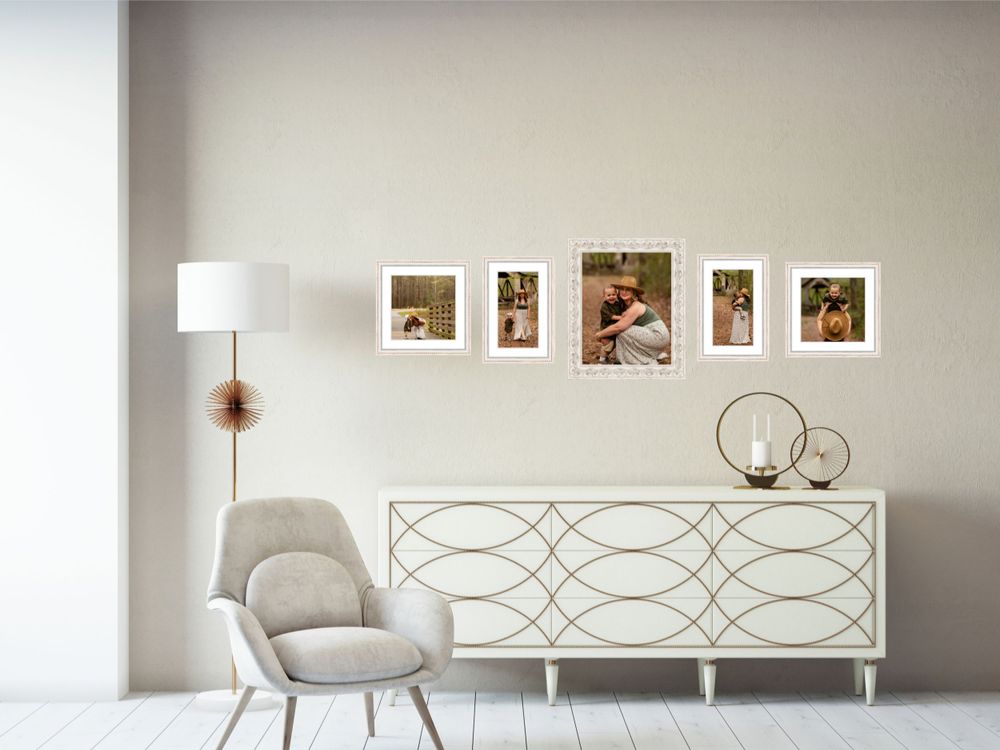 Elegant white living room featuring row of framed photographs above geometric patterned sideboard.